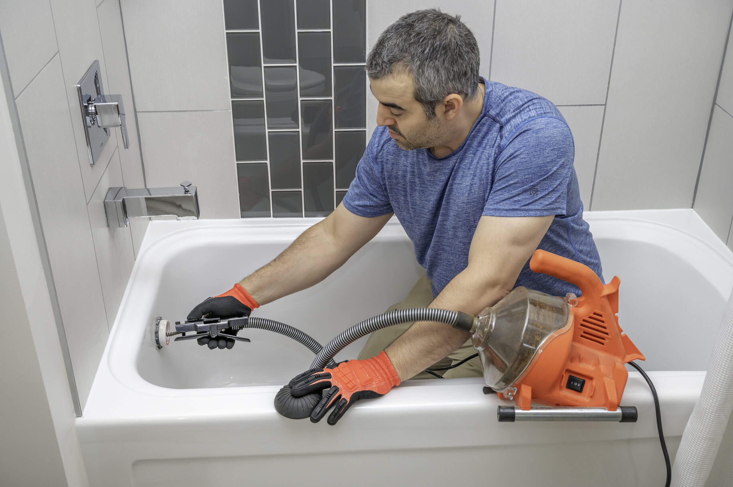 Badewannenabfluss wird mit einer Rohrreinigungsmaschine gereinigt